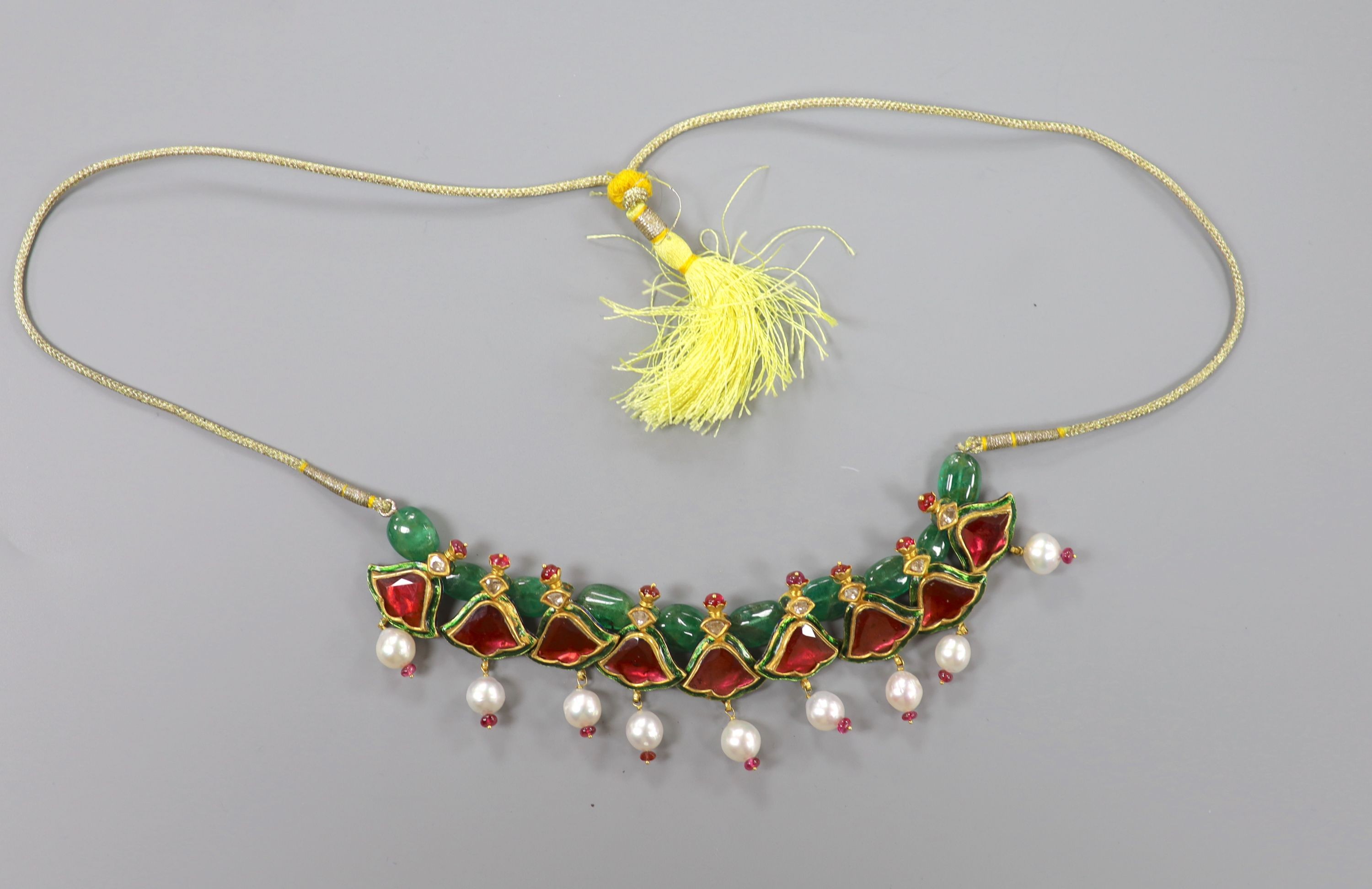 An Indian? emerald, garnet, ruby, enamel and cultured pearl set drop necklace, with fabric chain, overall approx. 68cm.